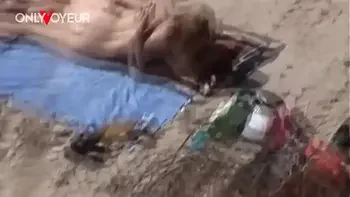 Beach Voyeur. Young nudist couple enjoying sex on the beach