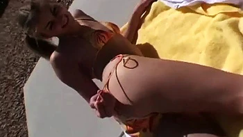 Hot blonde model shows off her body in a bikini in public