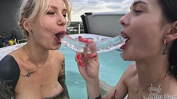 Two lesbians have fun at the pool with a toy in their pussy