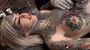 Sascha plays with Amber Luke while she gets tattooed