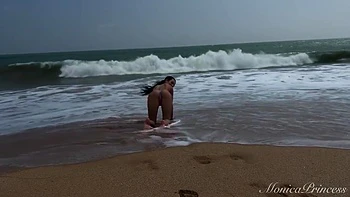 Nue sur la plage, elle se doigtaille la chatte en plein air