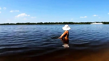 Loira naturista mostra tatuagens sozinha no rio